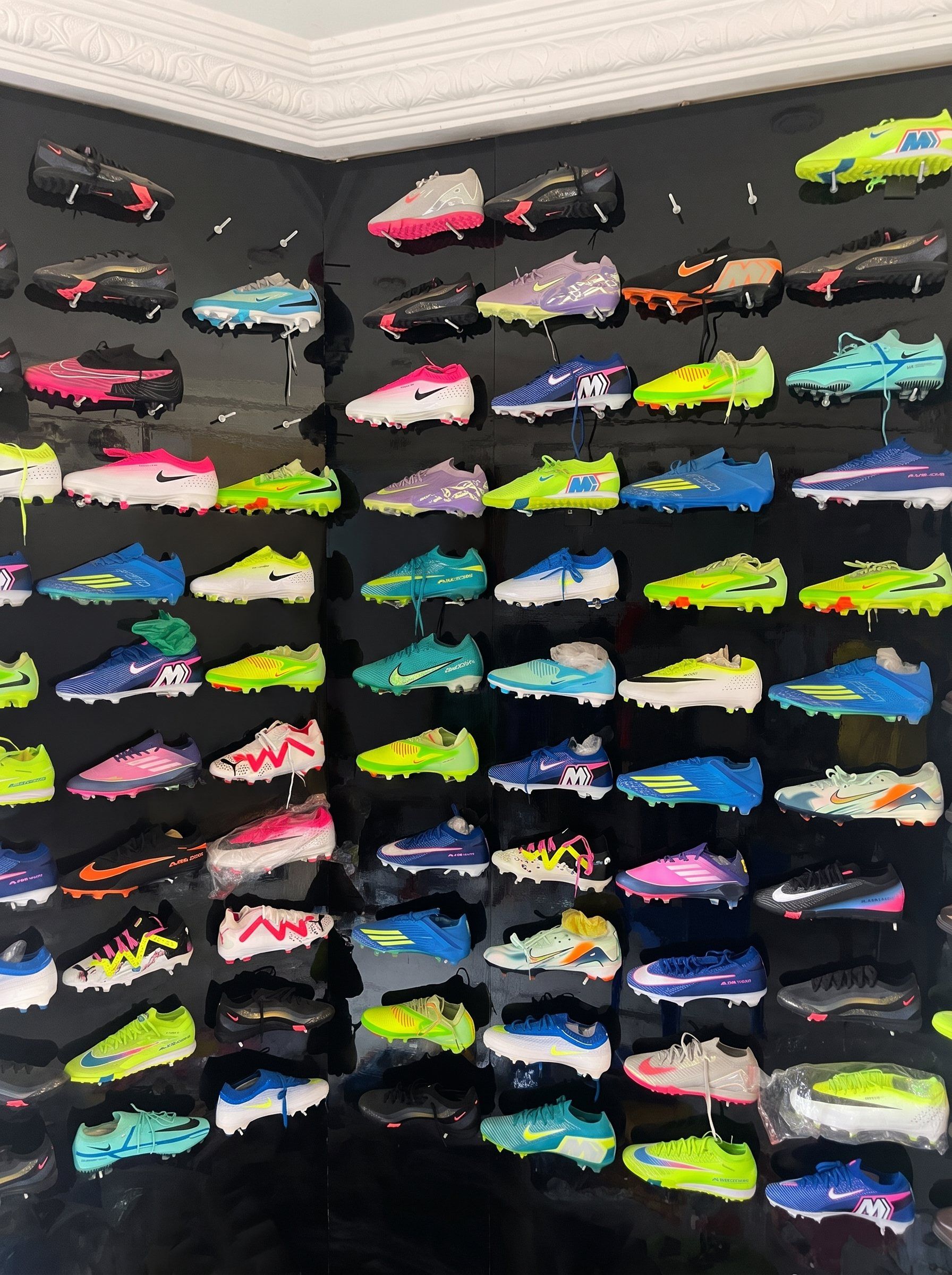Mur noir couvert de crampons de toutes les couleurs, rangés par rangées dans la boutique